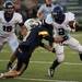 Pioneer senior running back Zachary Davis stiff arms while controlling the football  to score a touchdown in the first half against Saline High School on Friday. Pioneer won 7-6. Daniel Brenner I AnnArbor.com